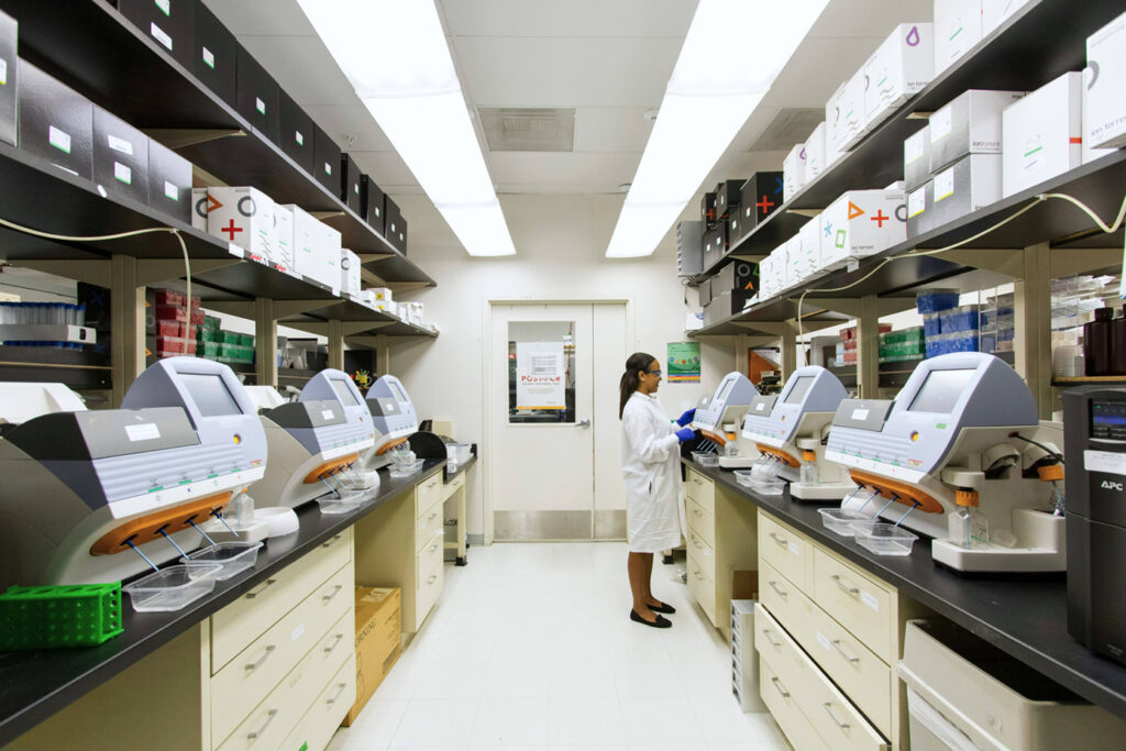 A cancer researcher working in a lab with expensive genotyping equipment